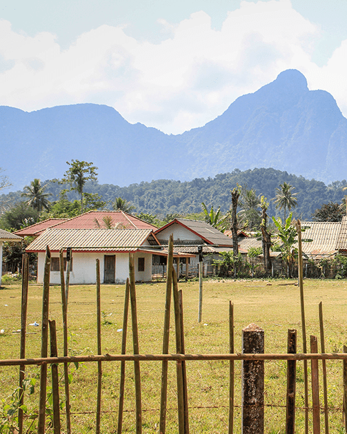 wide shot of a home surrounded by fields and mountains