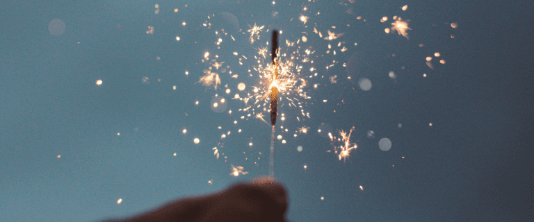 A hand holds a lit sparkler