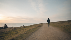 Person walking alone on a quiet path, representing the burden of shame and the hope of Christ.